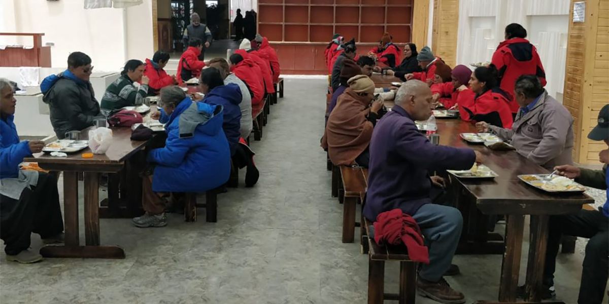 Yatris eating in a Madhuban dining hall on the Kailash route